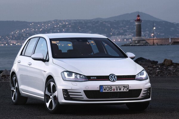 Volkswagen golf blanc sur fond de ville