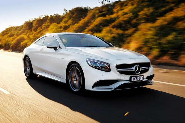 Mercedes blanche se précipite sur la route en dehors de la ville