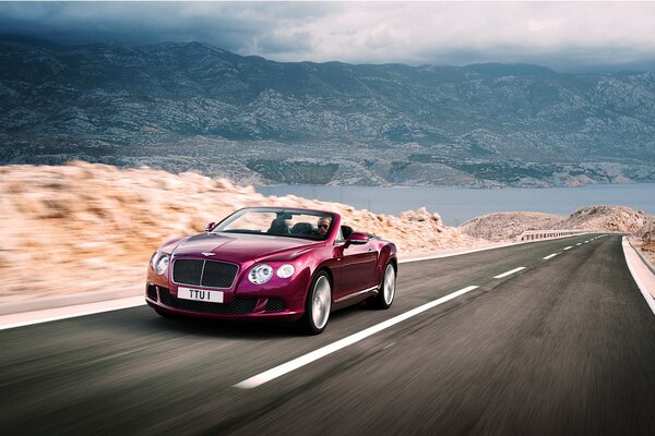 Purple Bentley on a mountain road