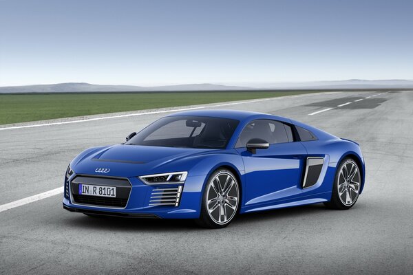 A blue Audi is driving on the road