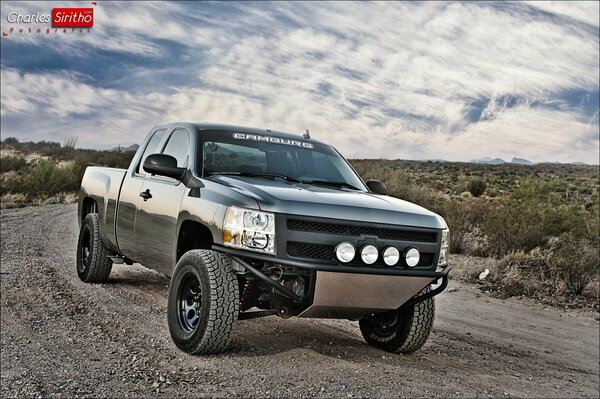 Chevrolet Silverado na drodze na tle nieba z chmurami