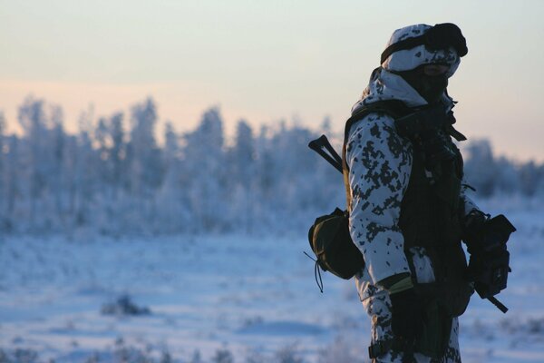 A soldier in a winter field with a weapon