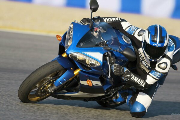 Pilot in a yamaha suit on a blue motorcycle