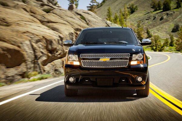 Une chevrolet 2013 roule sur une route de banlieue