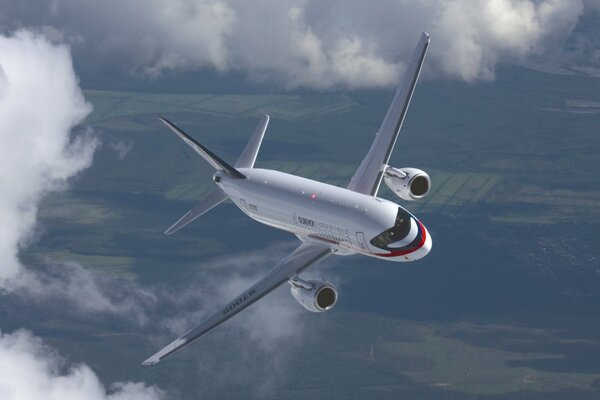 Superjet 100 Flugzeug im Flug über dem Boden