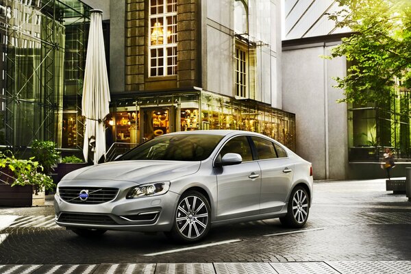 A gray Volvo is parked on a city street