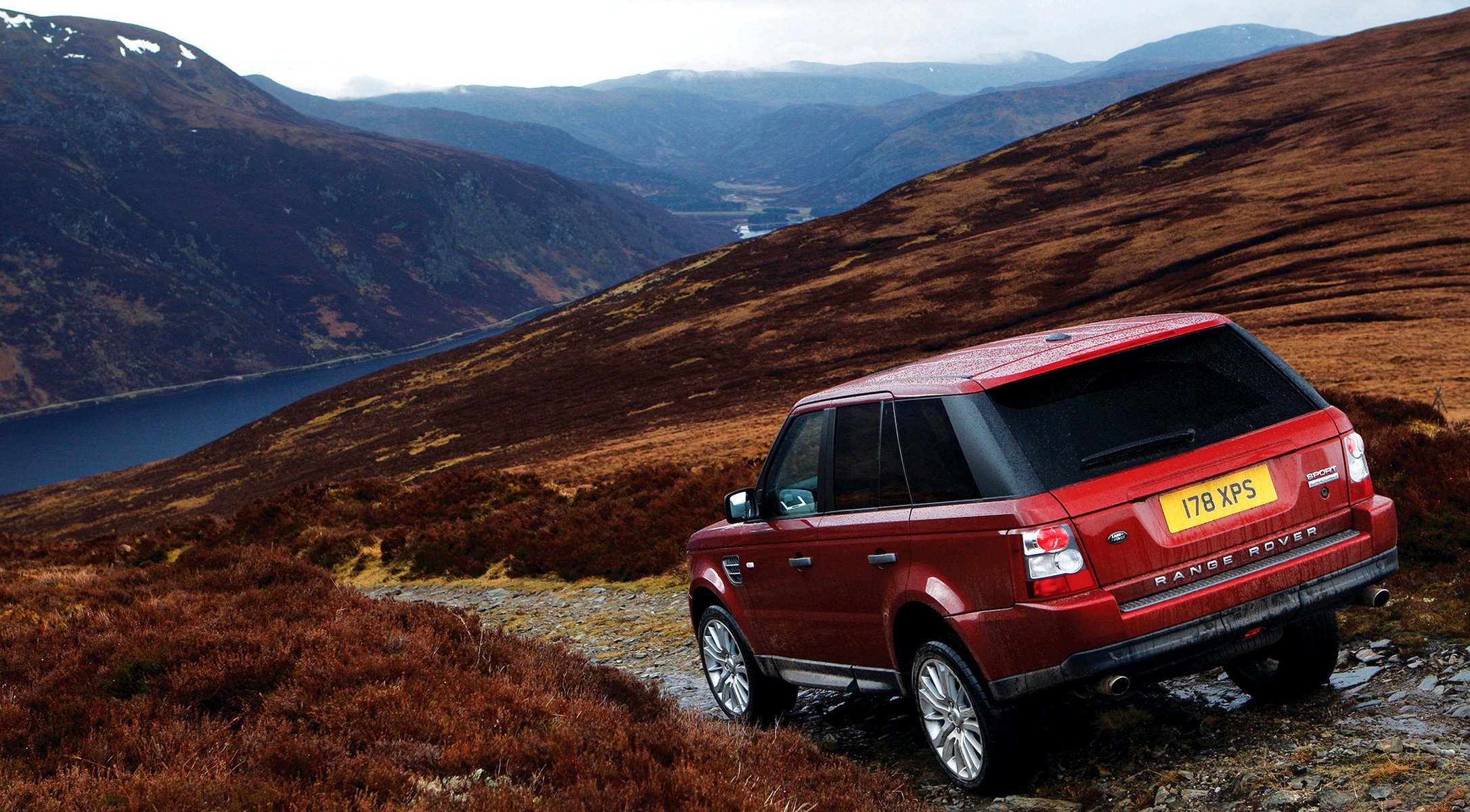 red mountains land rover auto car red car lake descent mountainous terrain landscape passenger cars cars motor transport women transport