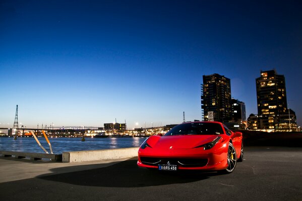 Sporty red Ferrari hypercar on the embankment