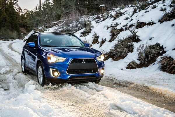 Blue car on a snowy road