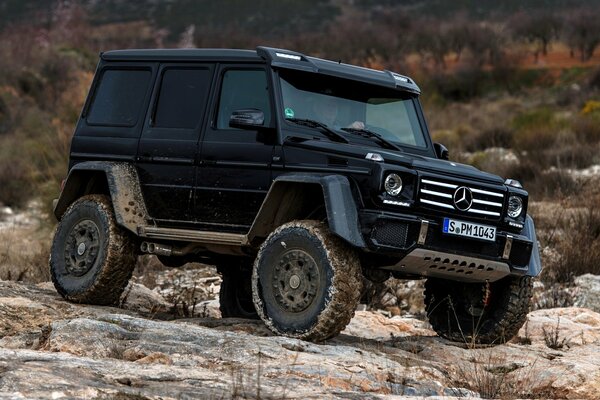 Black four-wheel drive Mercedes Benz g class on the rocks