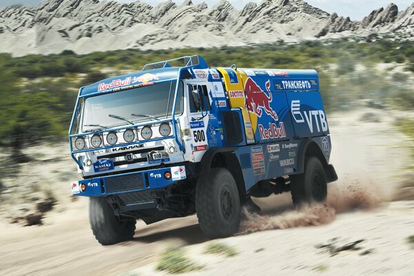 KAMAZ Dakar cabalga sobre la arena en medio de las montañas