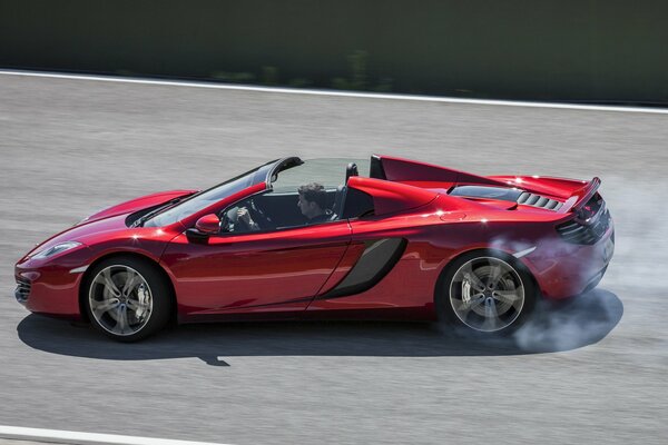 Bright red spider McLaren convertible at high speed