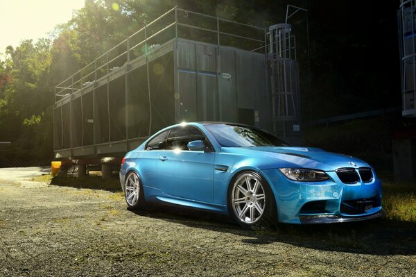 BMW m3e92 blu atlantico sullo sfondo di una foresta recintata soleggiata