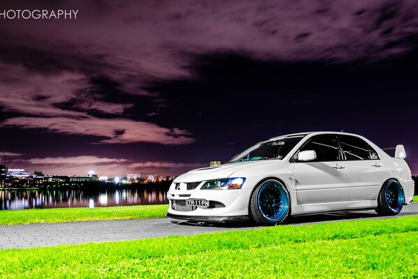 Mitsubishi car on the background of sunset and night lights