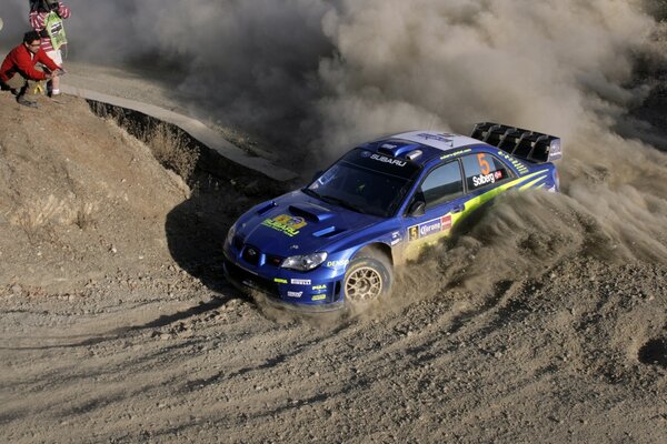 Subaru car drifts on a dusty road