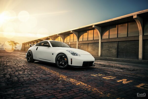 Nissan NISMO blanco en el fondo de la puesta de sol