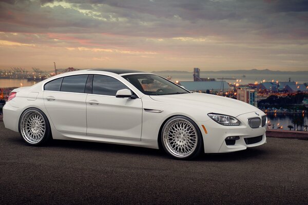 BMW 650i tuneado blanco en el fondo de la ciudad