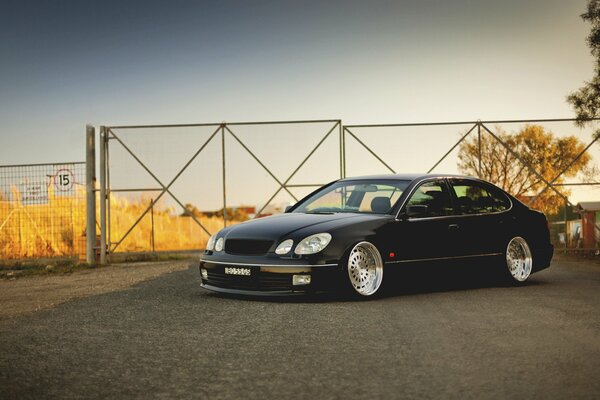 A black Lexus is standing at the gate