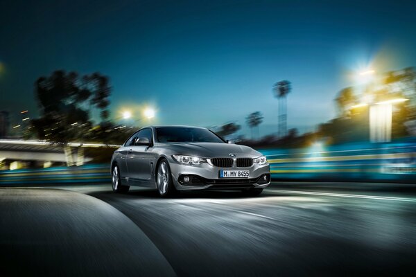 Grey bmw 4 series racing on the night track