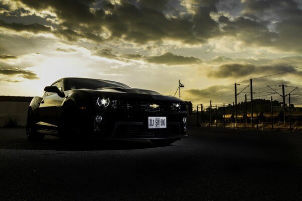 Black Chevrolet Camaro on the background of the night city