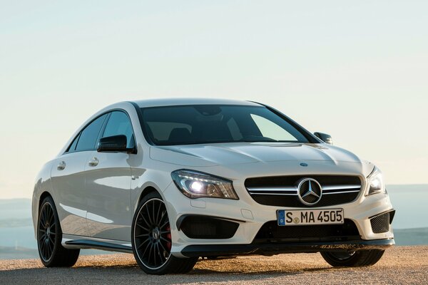 El coche blanco de Mercedes Benz está en la orilla