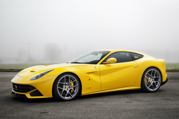 Coche amarillo de carreras fresco en medio de la niebla