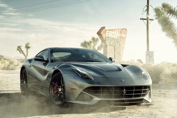 Coche ferrari F12 negro en el polvo de la carretera