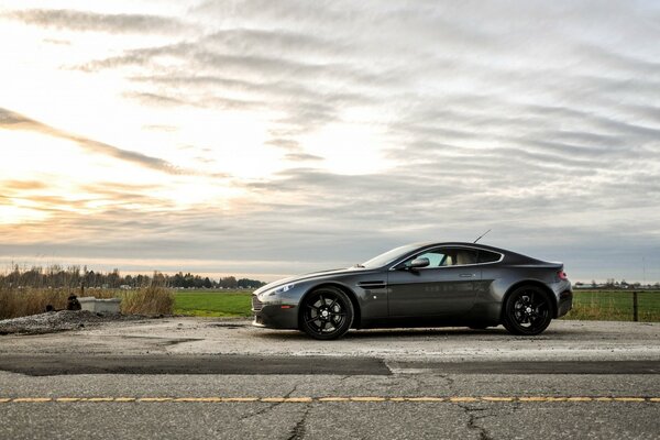 Aston martin na tle wiejskiego krajobrazu. Zachód. Czołg