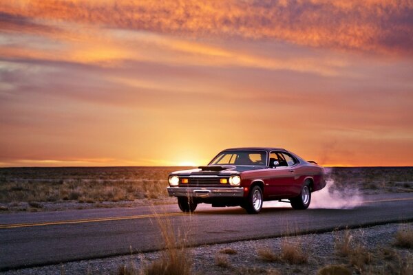 Plymouth rojo en el fondo de la hermosa puesta de sol