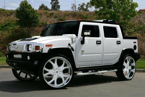 Un HUMMER ASANTI H2 tuneado blanco en medio de un colapso