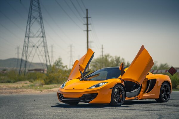 McLaren orange sur fond de supports haute tension