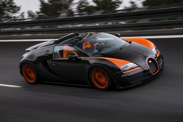 Coche deportivo negro y naranja en la carretera