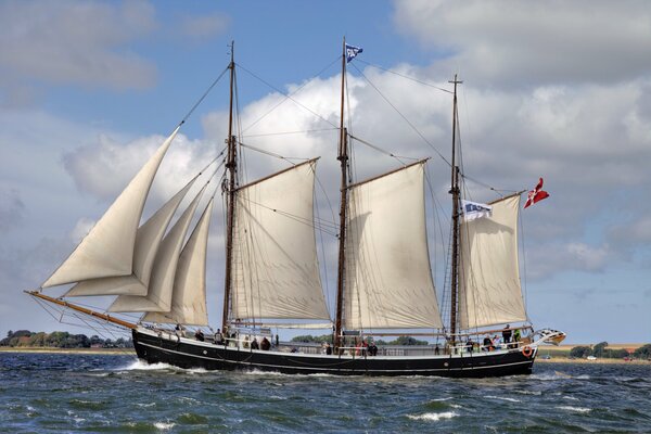 Ein Schiff mit erhobenen Segeln unter den Wellen