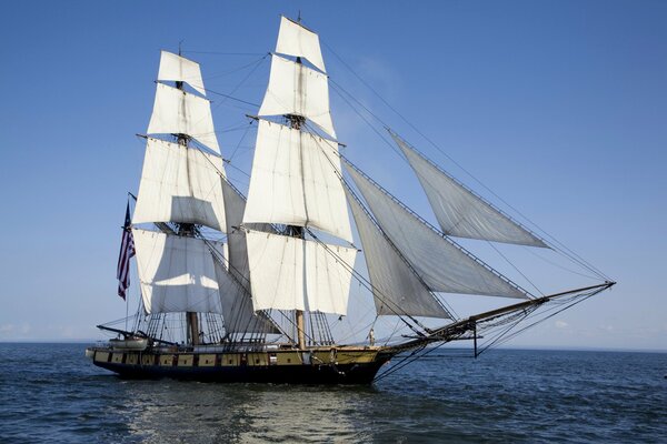 Una nave con vele bianche naviga in mare