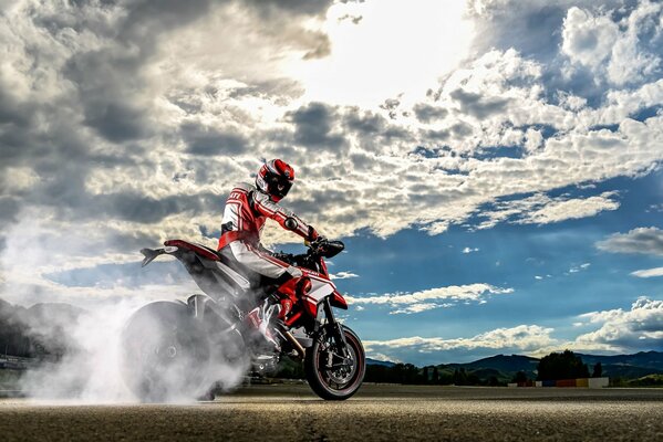 A motorcyclist rides against the background of a gorgeous sky