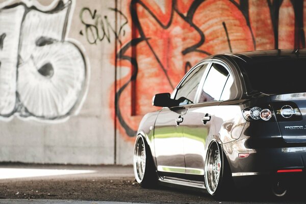 Voiture Mazda sur fond de mur avec graffiti