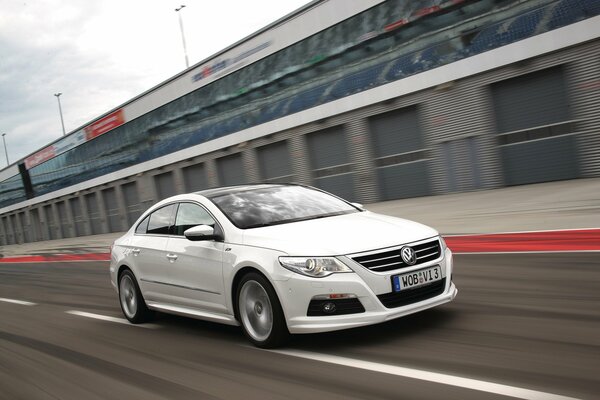 White Volkswagen Passat rushes along the highway