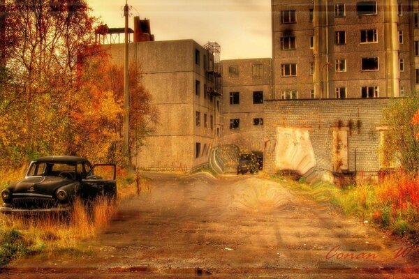 Verlassenes Auto auf dem Hintergrund der Geisterstadt im Herbst