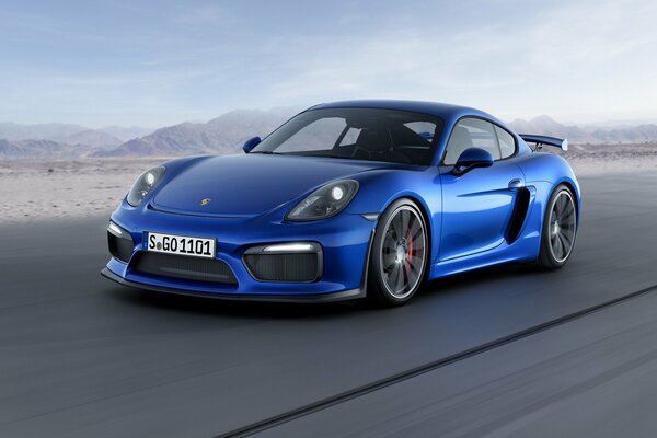 A blue Porsche car on the background of mountains