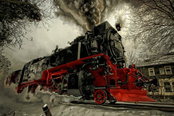 A painted steam locomotive rides on snow-covered rails