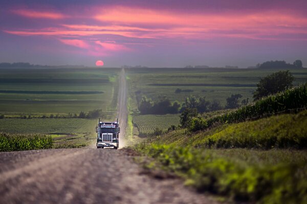 En el camino con una hermosa puesta de sol va el coche