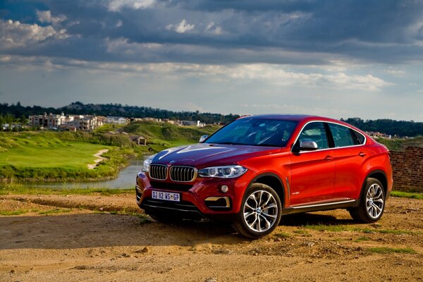 Rotes Auto bmw auf Wiese Hintergrund