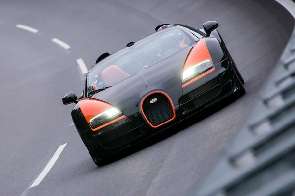 Voiture Bugatti Veyron noir et orange sur la piste