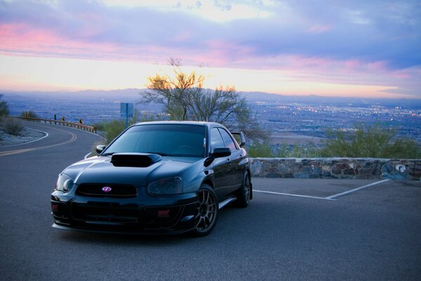 Subaru noir sur fond de grande ville