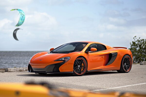 Orange McLaren supercar on the coast