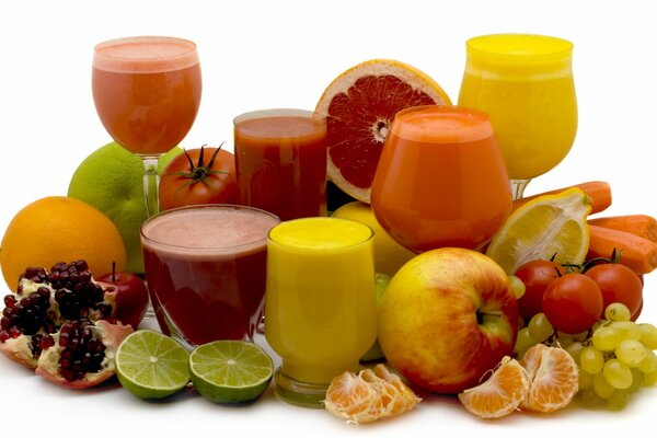 Jugos recién exprimidos sobre el fondo de la fruta