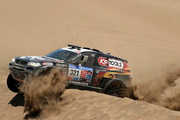 Black BMW x3 drives on sand dunes