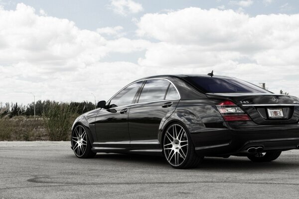 Mercedes on the background of a cloudy sky and trees