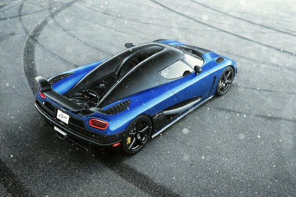 Blauer koenigsegg agera Supersportwagen auf der Winterstraße