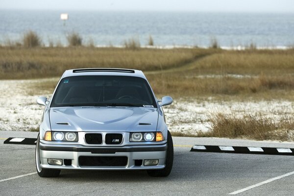 Silberner bmw e36 am Ufer